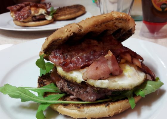 Panino alla piastra con hamburger bacon uovo e rucola